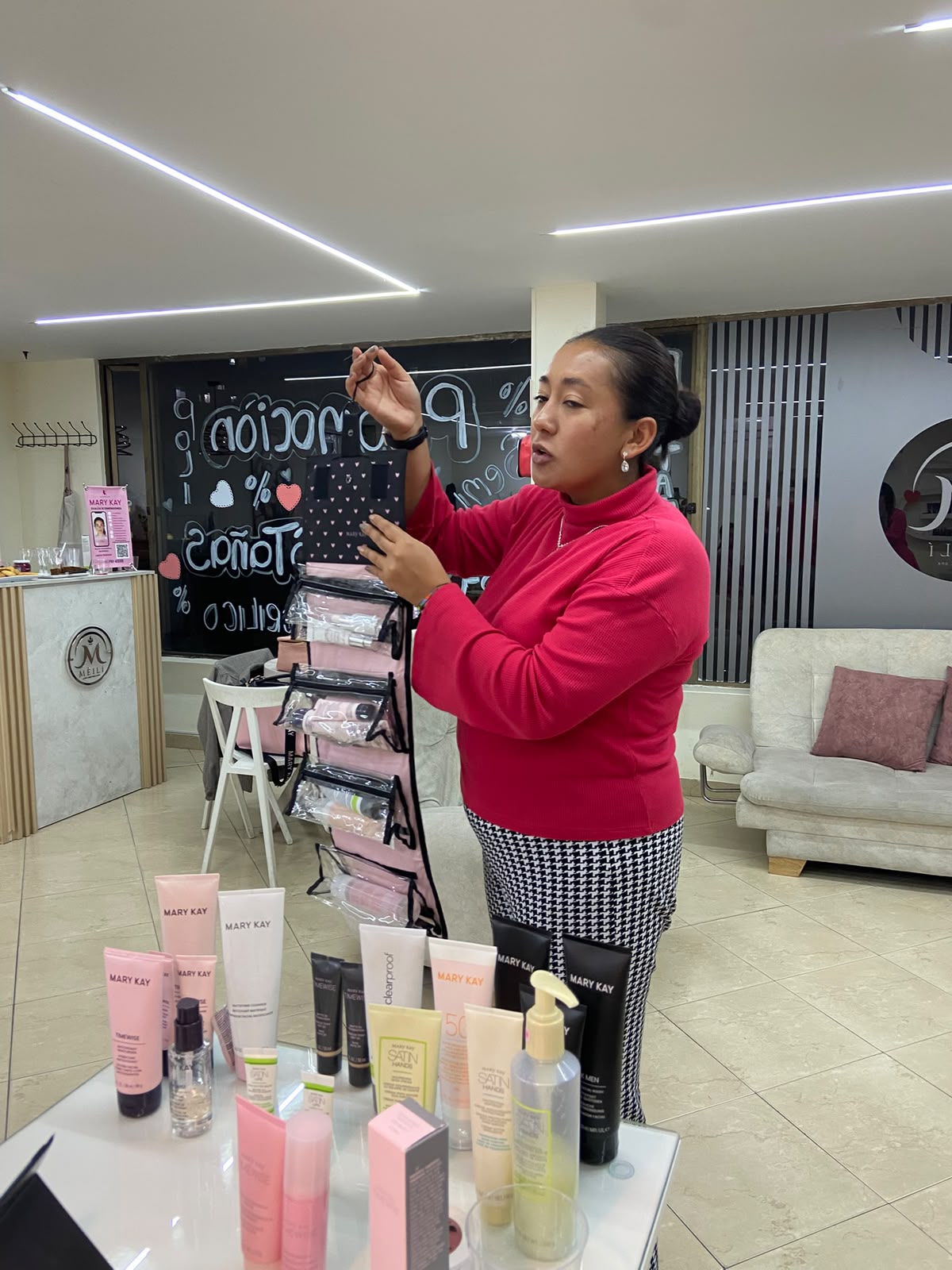 Consultora Mary Kay trabajando desde casa con su celular y productos